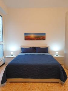 a bedroom with a bed with a blue comforter at Trilocale Lido di Roma in Lido di Ostia