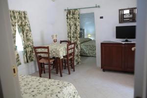 a room with a table and chairs and a television at Agriturismo Masseria Casedde Vecchie in Martina Franca