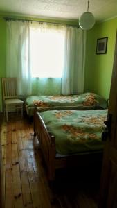 a bedroom with two twin beds and a window at Viesu nams Klāņas in Engure