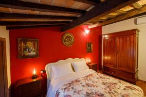 サン・マルティーノ・イン・カンポにあるBed & Breakfast Zoccoの赤い壁のベッドルーム1室、ベッド1台(白い枕付)
