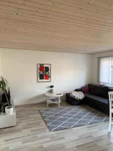 un soggiorno con divano nero e tavolo di Modern cozy 2 bedroom apartment near City center a Pärnu