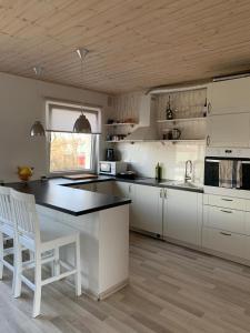 una cucina con armadi bianchi e piano di lavoro nero di Modern cozy 2 bedroom apartment near City center a Pärnu