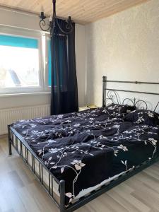 una camera da letto con un letto con copriletto nero e una finestra di Modern cozy 2 bedroom apartment near City center a Pärnu