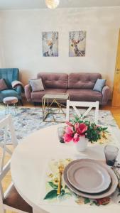 uma sala de estar com uma mesa branca e um sofá em Julia apartments next to AQUA PARK em Druskininkai