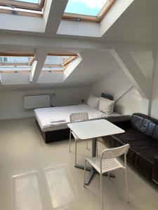 a room with a bed and a couch and a table at Apartamenty Hoża Attic Studio in Warsaw