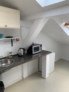 a kitchen with a counter with a microwave on it at Apartamenty Hoża Attic Studio in Warsaw