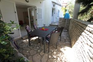 a black table and chairs on a patio at Apartment Bianca Premantura Istrien in Premantura