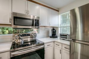 una cocina con electrodomésticos de acero inoxidable y armarios blancos en Moon River Suites #5, en North Bend