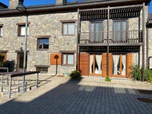 Edificio de ladrillo con balcón y patio en Fantástico Apartamento con jardín en Castiello de Jaca, en Castiello de Jaca