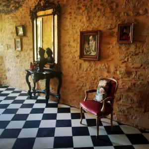 a room with a table and a chair and a mirror at B&B Château de Fajac la Selve in Pech-Luna