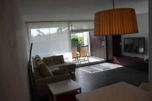 sala de estar con sofá y ventana grande en Bonito apartamento con jardín, en Platja d'Aro