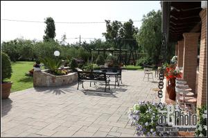 a patio with a table and chairs and flowers at Casale Del Borgo in Hermada