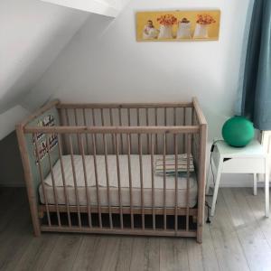 OudesluisにあるHouse on park "Zijper Eilant"のテーブルと写真付きの部屋のベビーベッド