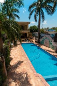 a swimming pool with palm trees in front of a house at Best Western Hotel Plaza Matamoros in Matamoros
