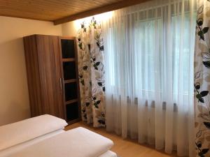 Schlafzimmer mit einem Bett und einem Fenster mit Vorhängen in der Unterkunft Ferienwohnung Hafner in Mayrhofen