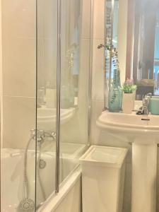 ein weißes Badezimmer mit Dusche und Waschbecken in der Unterkunft MimApartment In Front Beach Oporto in Matosinhos