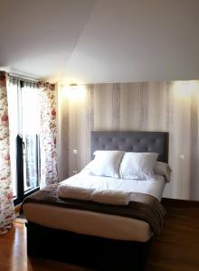 a bedroom with a large bed with a large window at Apartamento Dúplex Golf Rioja Alta in Cirueña