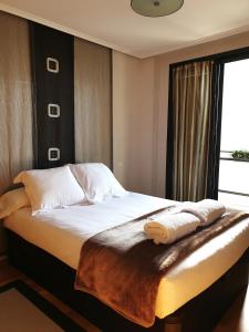 1 dormitorio con 1 cama con sábanas blancas y ventana en Apartamento Dúplex Golf Rioja Alta, en Cirueña