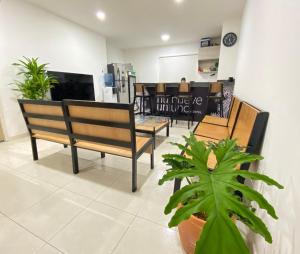 una stanza con due panche e una tv in un negozio di Nueve Uno Hostel a Ríohacha