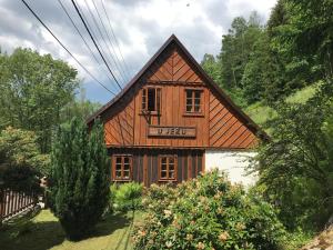 a wooden house in the middle of a yard at Chalupa U Jezu in Tanvald