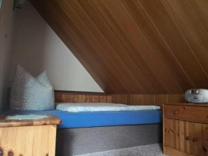 Bett in einem Zimmer mit Holzdecke in der Unterkunft Haus Franziska in Leck