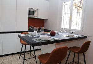 - une cuisine avec une table et des verres à vin dans l'établissement La casa in via della Torre, à Modène