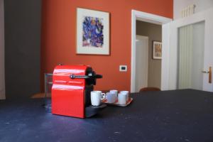 - une machine à café rouge assise sur une table avec des tasses dans l'établissement La casa in via della Torre, à Modène