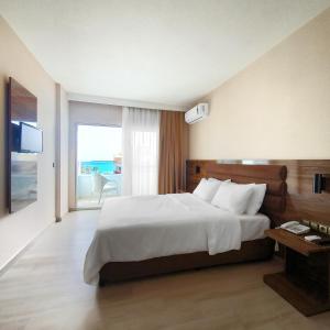 a bedroom with a large bed and a large window at Ozgur Bey Spa Hotel in Alanya