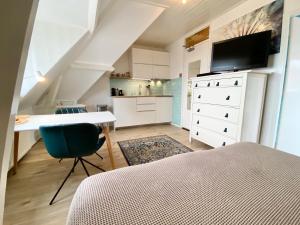 a bedroom with a bed and a desk and a kitchen at Odyssee in Zandvoort