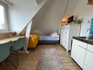 um pequeno quarto com uma secretária e uma cama em Odyssee em Zandvoort