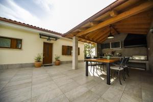 - patio z drewnianym stołem i krzesłami w obiekcie Casa Tilia w mieście Šapjane