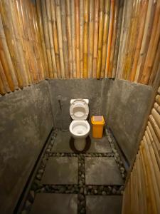 a small bathroom with a toilet in a bamboo structure at Balay Hayahay Clohaki Hostel in General Luna