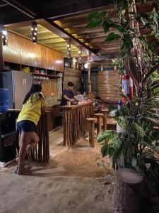 a woman standing at a counter in a kitchen at Balay Hayahay Clohaki Hostel in General Luna