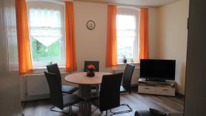 un soggiorno con tavolo, sedie e TV di Haus Waldeck a Kurort Altenberg