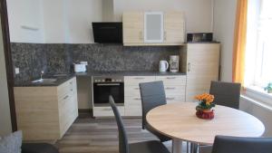 una cucina con tavolo e sedie e una cucina con lavandino di Haus Waldeck a Kurort Altenberg