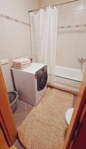 a bathroom with a washing machine on the floor at Julia apartments next to AQUA PARK in Druskininkai