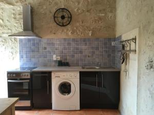 een keuken met een wasmachine en een wastafel bij Lavande- Gasquerie gites in Puisseguin