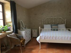een slaapkamer met een bed, een stoel en een dressoir bij Lavande- Gasquerie gites in Puisseguin