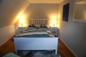 um quarto com uma cama branca com duas mesas de cabeceira em Tier- & kinderfreundliches Ferienhaus - KEINE MONTEURE em Priesendorf