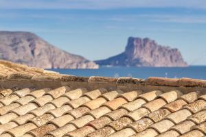 a roof of a building with a mountain in the background at Hotel Tossal d'Altea in Altea