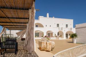 a patio with a white building in the background at Masseria D'Erchia in Monopoli