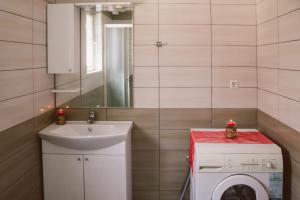 a bathroom with a sink and a washing machine at Golden House in Sarajevo