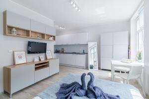 a white room with a bed and a kitchen at Apartment New & Nice in Gdańsk
