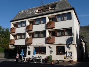 ein weißes Gebäude mit Blumen in den Fenstern in der Unterkunft Hotel-Garni-Sonnenlay in Bernkastel-Kues