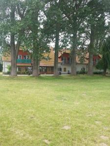 a large building with trees in a field at Haus Müritz, FeWo 17 Hecht in Zielow