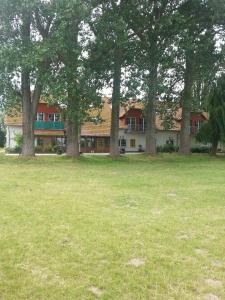 a large building with trees in a field at Haus Müritz, FeWo 17 Hecht in Zielow +3 photos