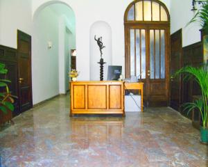 un bureau avec un bureau en bois dans une pièce ornée de plantes dans l'établissement Casa Gori, à Certaldo