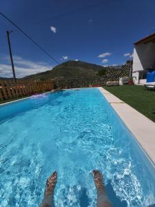 a person with their feet up in a swimming pool at Casa da Padaria in Folgosa