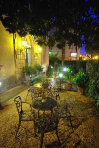 - un groupe de tables et de chaises dans une cour la nuit dans l'établissement Casa Gori, à Certaldo