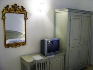 Cette chambre dispose d'une télévision sur une table et d'un miroir. dans l'établissement Casa Gori, à Certaldo